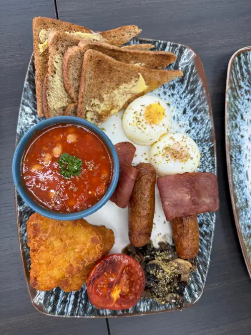 An English-style breakfast at Rumi: two eggs, turkey rashers, chicken sausages, a hash brown, grilled mushrooms, roasted tomato, baked beans and buttered toast.